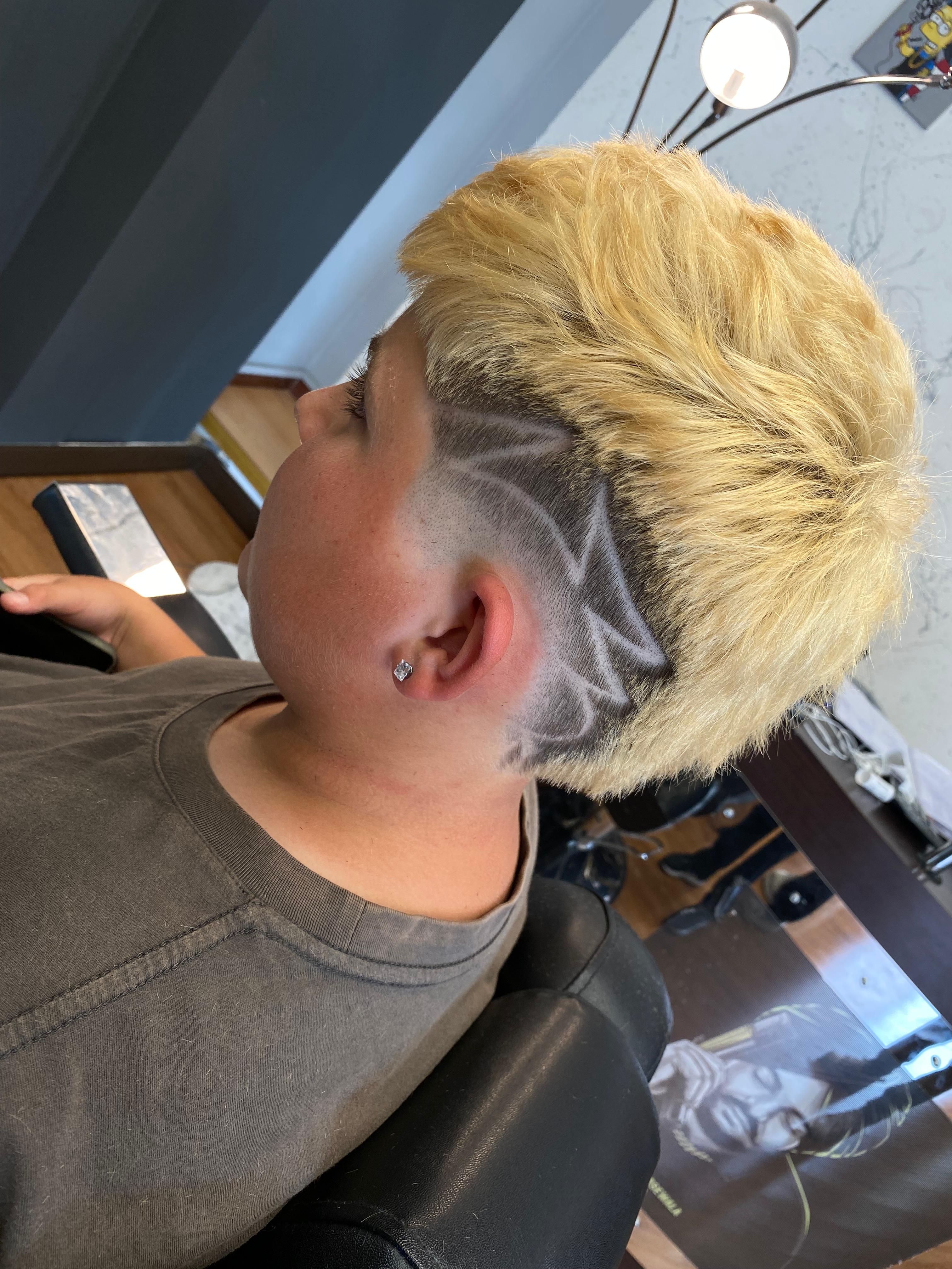 Capelli biondi platino con fade e design